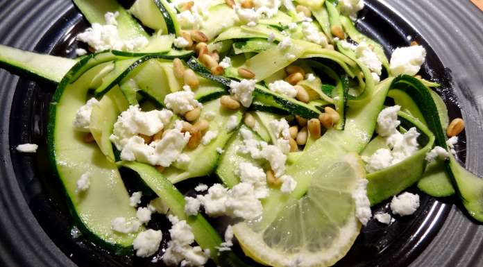 émietter la feta sur la salade de courgette